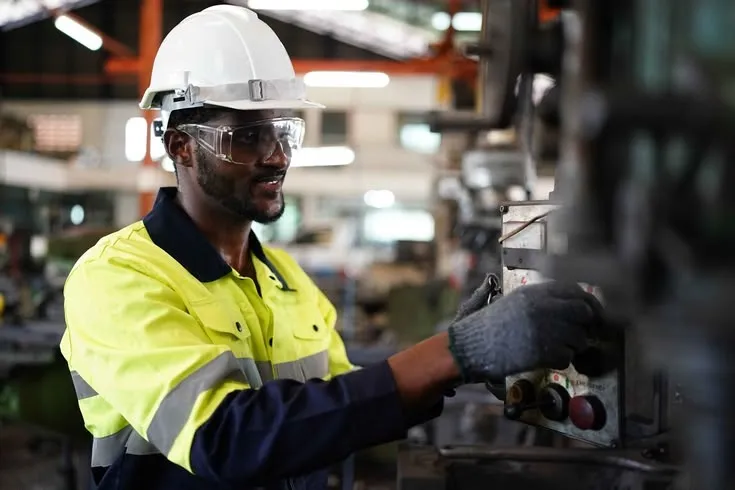 This may contain: a man in safety gear working on an assembly line