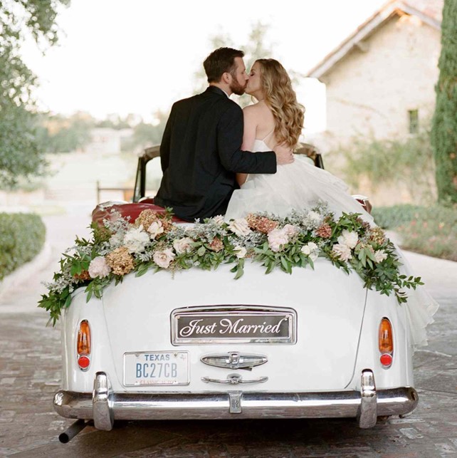 Bride in fine jewelry stepping out of a luxury wedding car