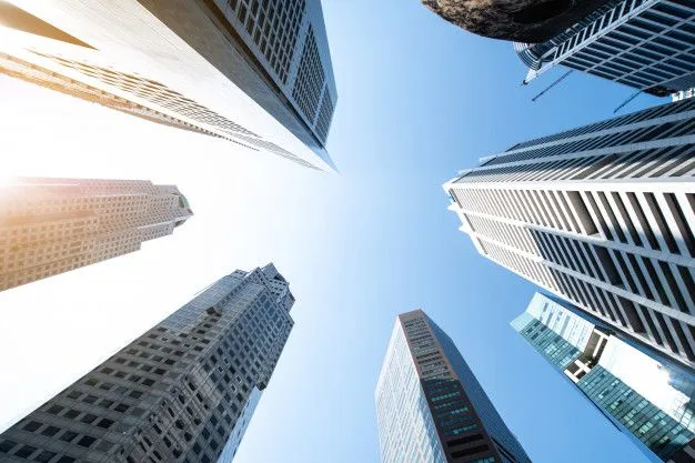 This may contain: looking up at skyscrapers from the ground to the sky with sun shining on them