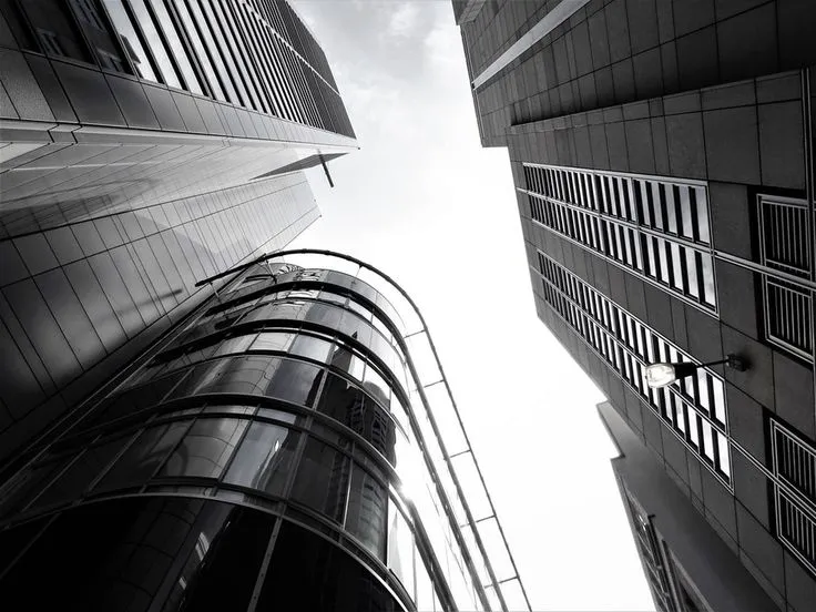 This may contain: looking up at two tall buildings from the ground, with one building in the foreground