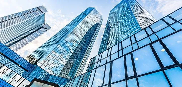 This may contain: the tall buildings are all glassy and very high up in the air, with blue sky reflected on them