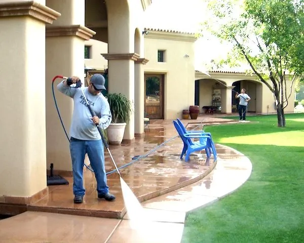 This may contain: a man using a pressure washer on a patio
