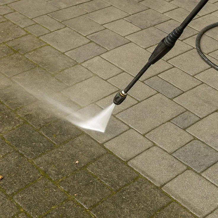 This may contain: a person is using a hose to spray water onto the ground with a pressure washer