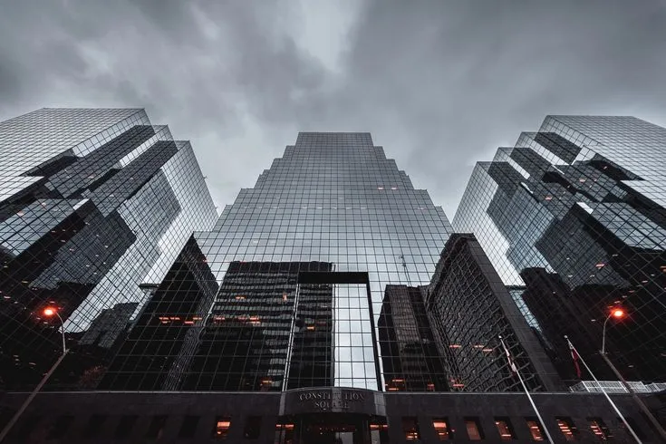 This may contain: looking up at the tops of skyscrapers in new york city on a cloudy day