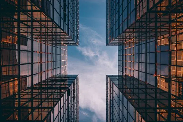 This may contain: looking up at tall buildings in the sky with lights shining down on them, from below