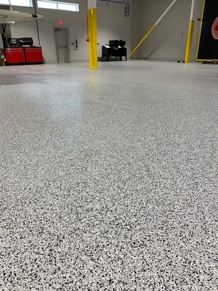 This may contain: an empty garage with white and black speckles on the floor