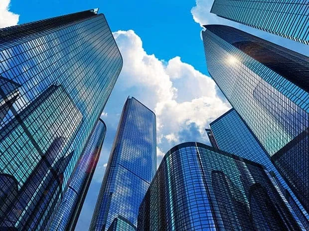 This may contain: looking up at tall buildings with blue sky and clouds in the backgrounnd