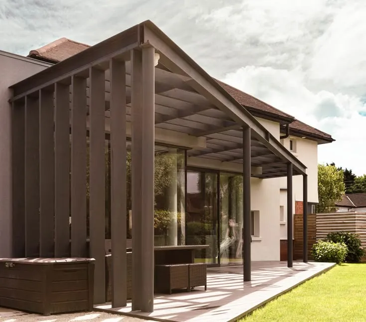 This may contain: a house with a covered patio and hot tub