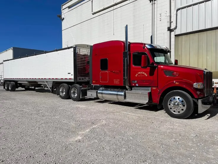 This may contain: a red semi truck parked in front of a building