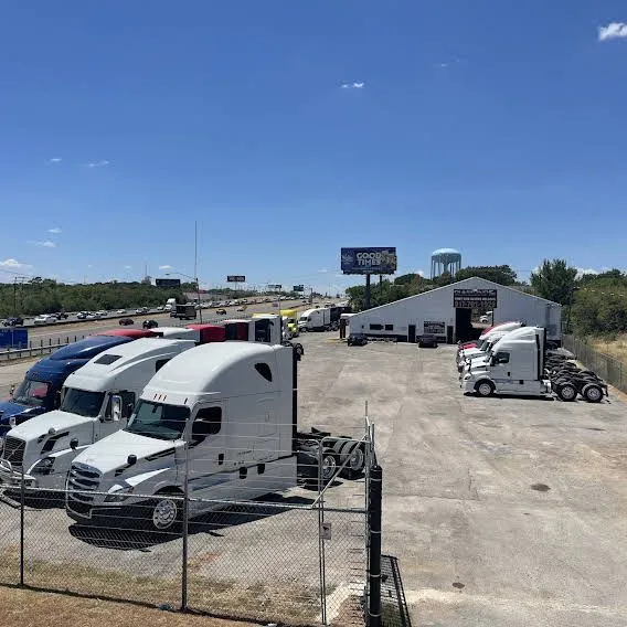 This may contain: several trucks are parked in a parking lot