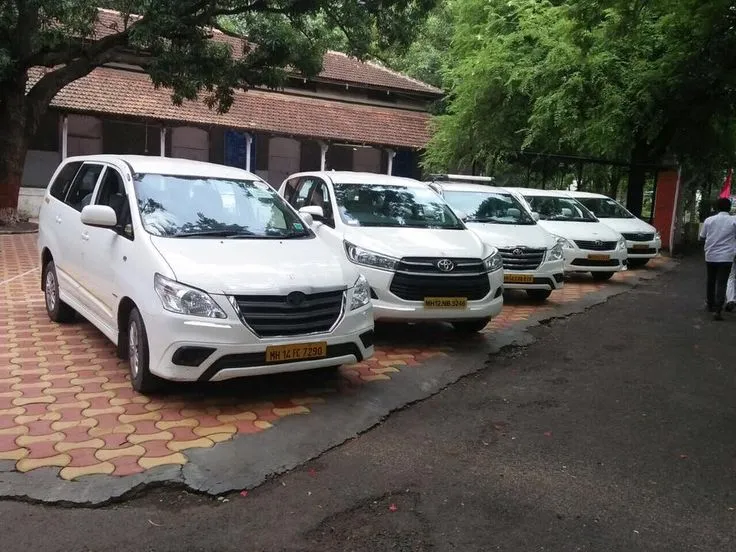 This may contain: a row of white vans parked next to each other on a brick road near a building