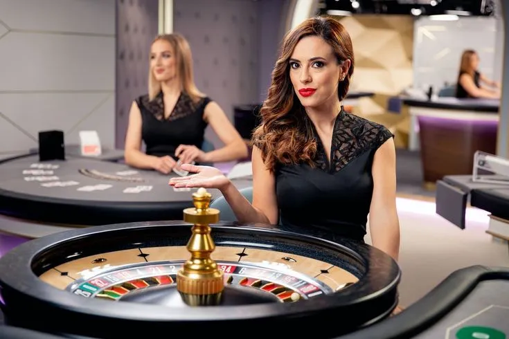 This may contain: two beautiful women sitting at a casino table with rouleets in front of them