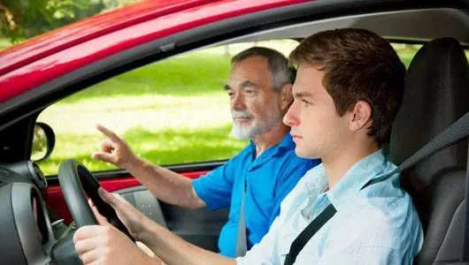This may contain: two men sitting in the driver's seat of a red car, one driving
