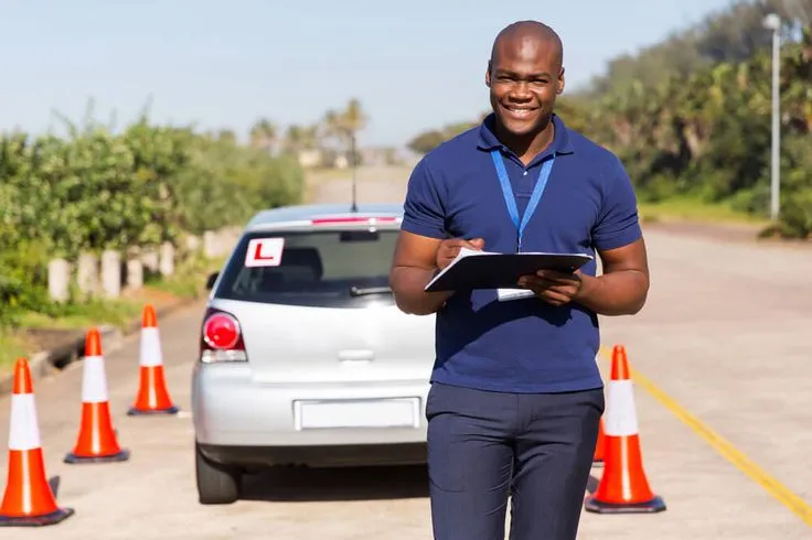 This may contain: a man standing in front of a car holding a clipboard