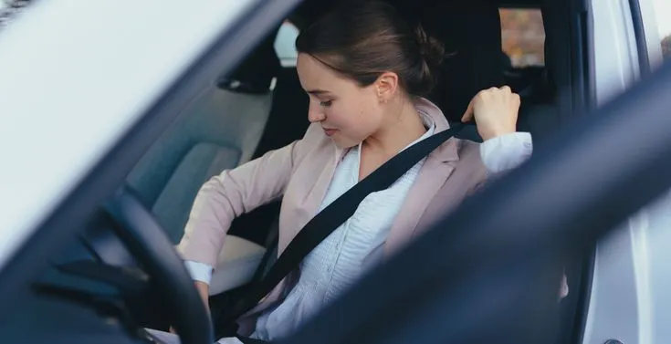 This may contain: a woman sitting in the back seat of a car