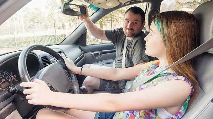 This may contain: a man and woman sitting in the driver's seat of a car