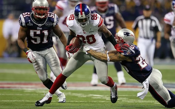 This may contain: a football player is being tackled by two other players