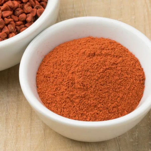 This may contain: two bowls filled with red food on top of a wooden table