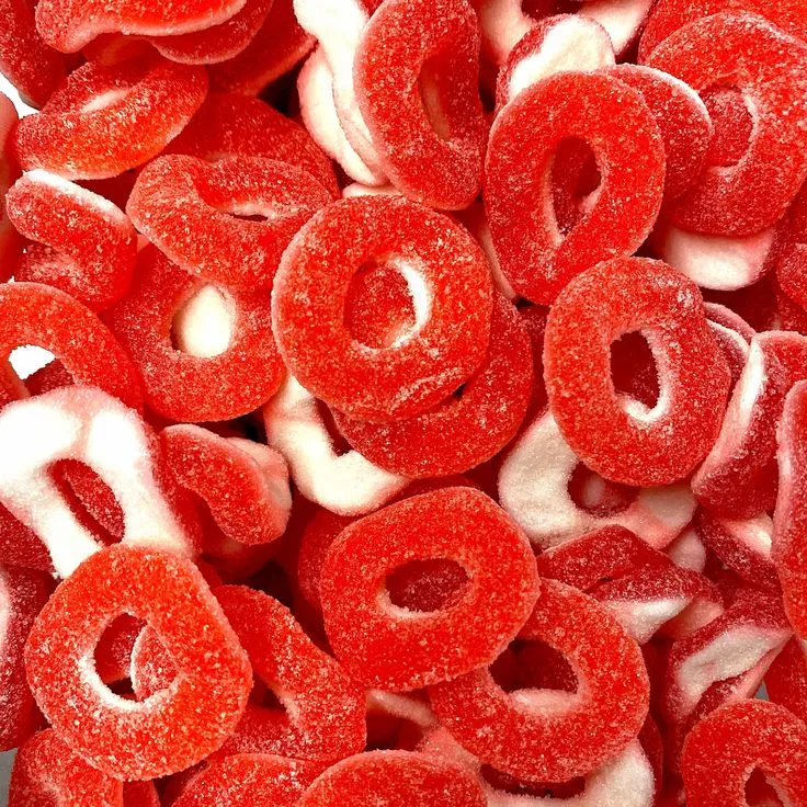 This may contain: red and white sugar coated donuts sitting on top of each other
