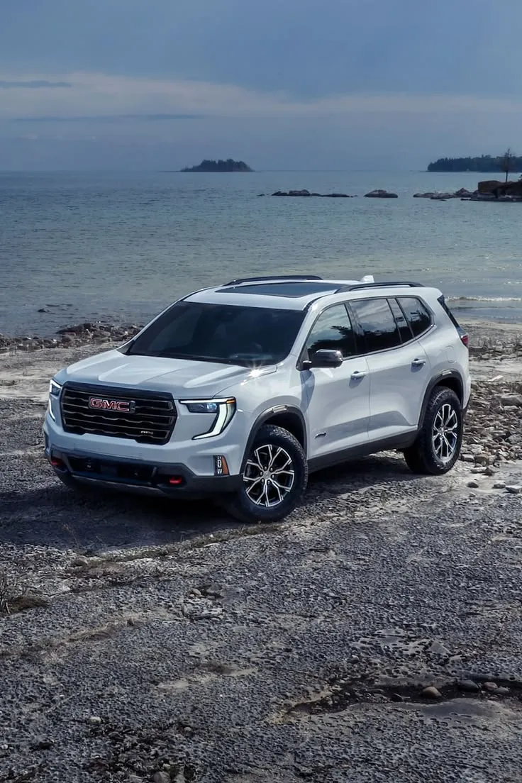 This may contain: a white suv parked on top of a rocky beach
