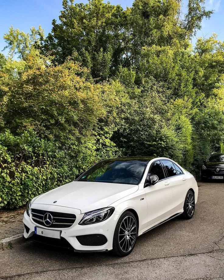 This may contain: two cars parked next to each other in front of trees