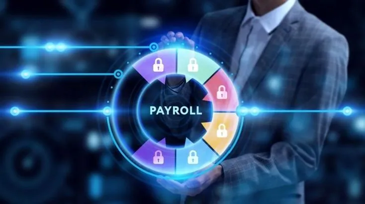 This may contain: a man in a business suit holding a button with the word payroll on it