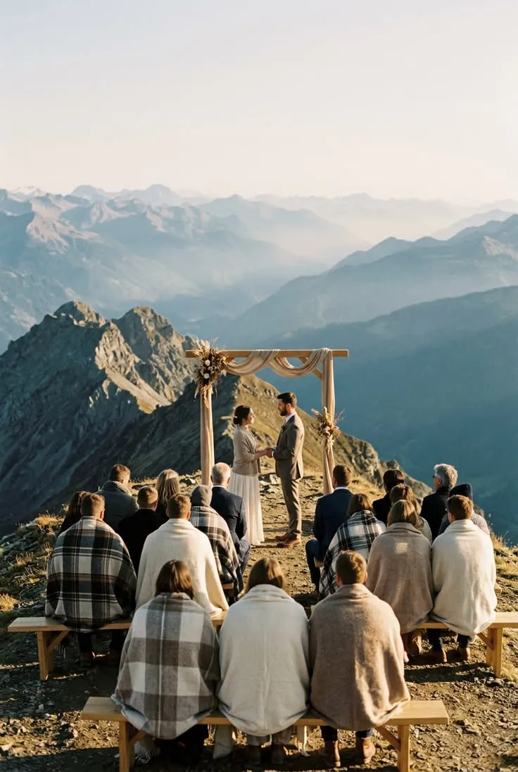 This may contain: a group of people sitting on top of a mountain
