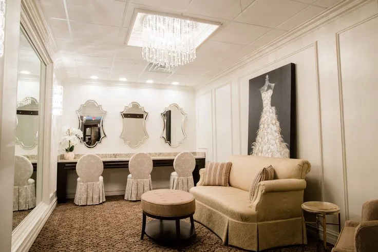 This may contain: a living room filled with furniture next to a wall mounted mirror and chandelier