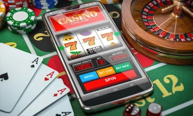 This may contain: a cell phone sitting on top of a table next to casino chips and playing cards