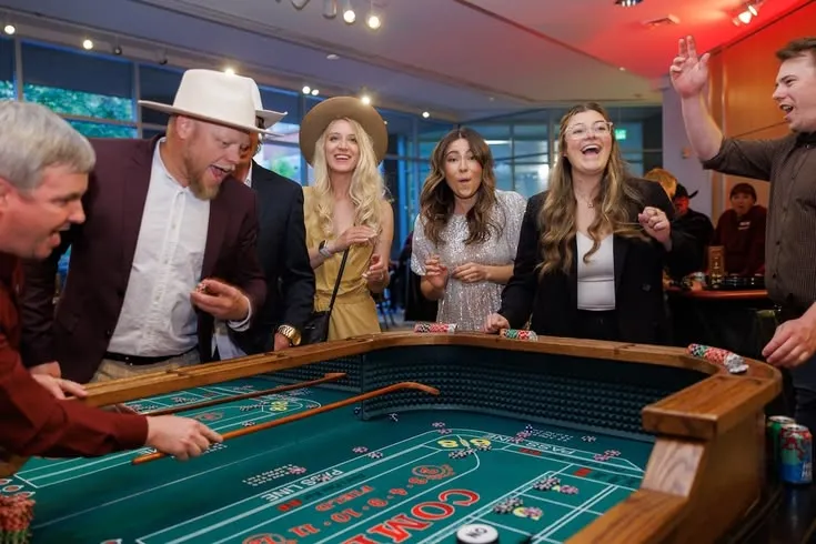 This may contain: a group of people standing around a rouleette table playing crapo at a casino