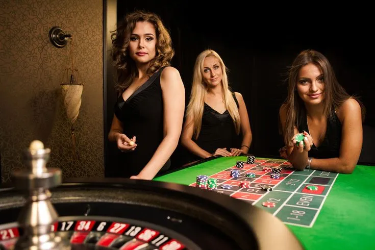 This may contain: three beautiful young women sitting at a casino table with roulejack chips in front of them