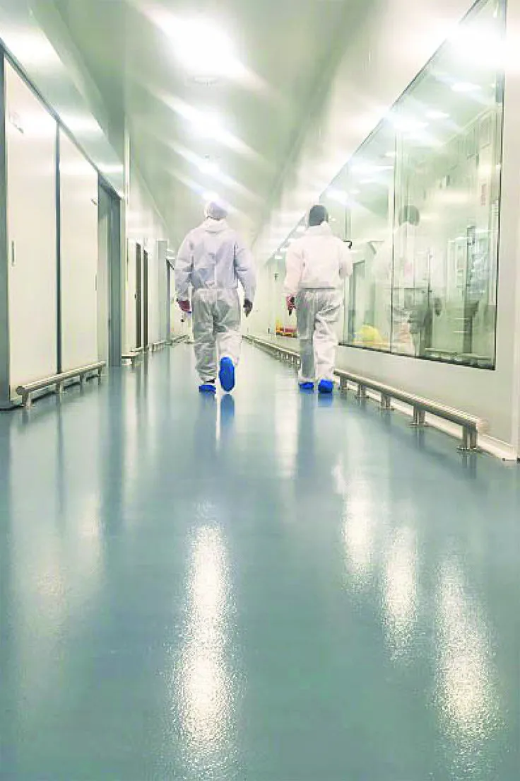 This may contain: two people in white suits walking down a long hallway with mirrors on the wall and floor