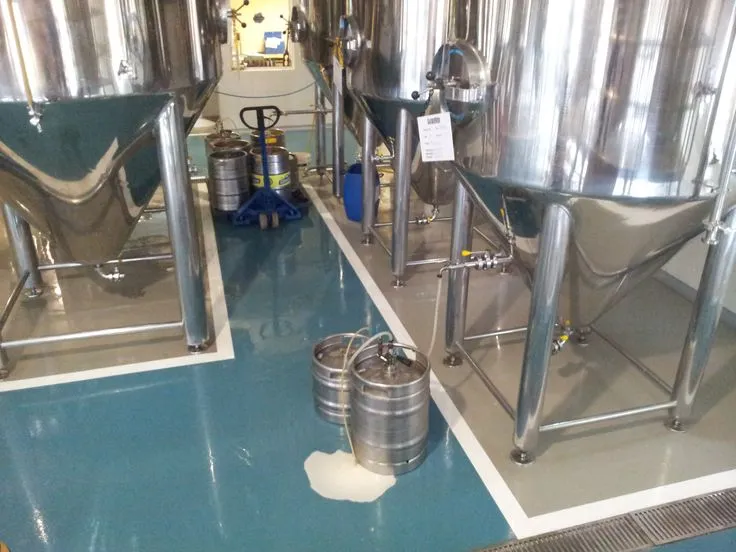 This may contain: several stainless steel tanks are lined up in a room with blue flooring and white walls