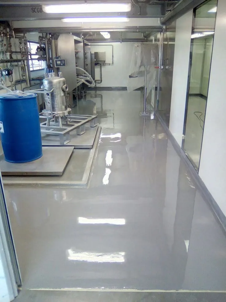 This may contain: an empty room with some blue barrels in the center and white walls on either side