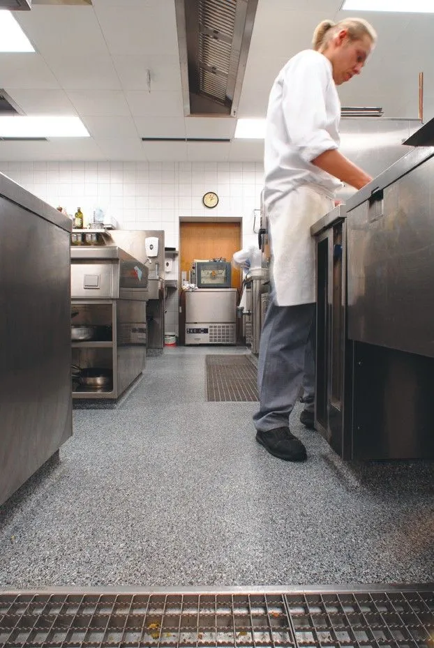 This may contain: a woman standing in a kitchen preparing food on top of a stove and ovens