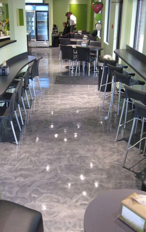 This may contain: an empty restaurant with tables and chairs in front of the counter area, while people are sitting at their desks