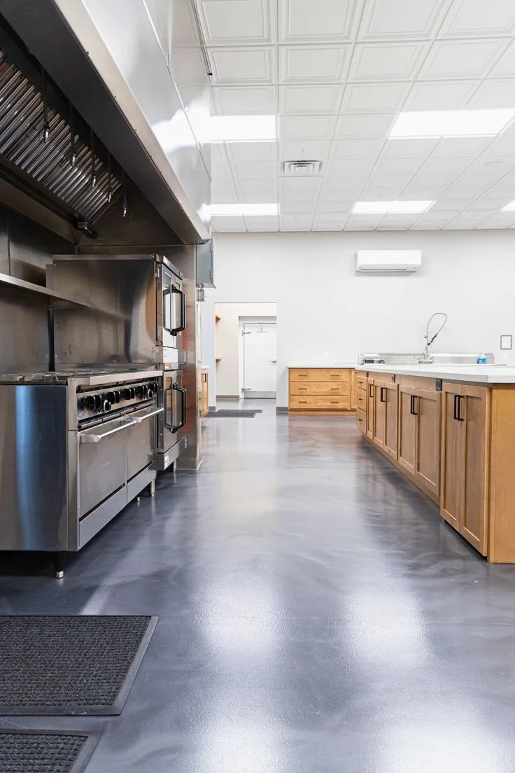 This may contain: an industrial kitchen with stainless steel appliances and wood cabinets