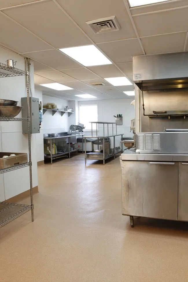 This may contain: a commercial kitchen with stainless steel appliances and shelving
