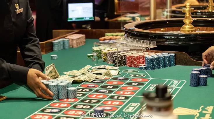 This may contain: two people playing roulend in a casino with lots of cards and chips on the table