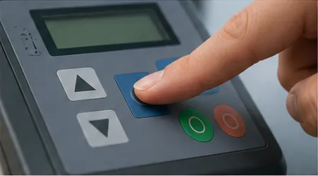 Illustrative view of a fingertip pressing a physical membrane key in an assembled instrument enclosure. Not a documented product test.