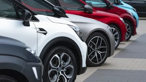 This may contain: a row of cars parked next to each other