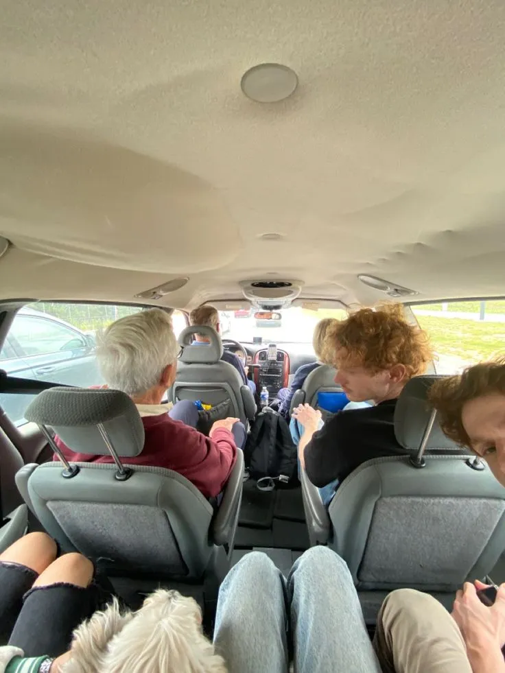 This may contain: three people sitting in the back seat of a car