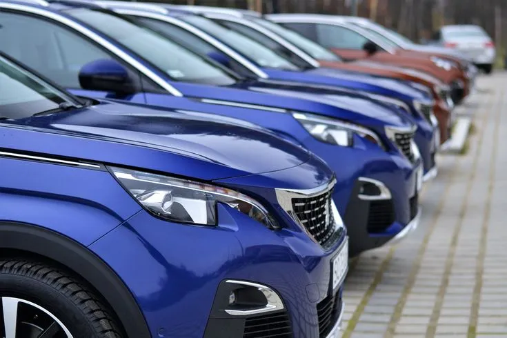 This may contain: a row of blue cars parked next to each other
