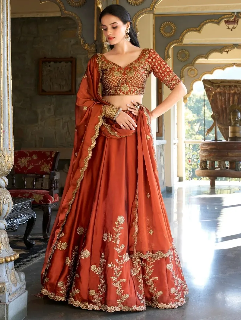 Rust orange lehenga choli with gold embroidery, perfect for Indian weddings and festive occasions