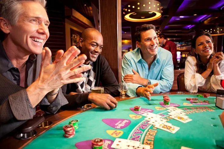 This may contain: four people sitting at a casino table clapping