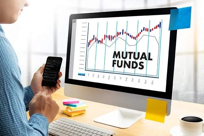 This may contain: a man holding a cell phone in front of a computer screen with the words mutual funds on it