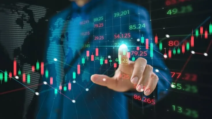 This may contain: a man in a business suit is pointing to an upward arrow on a screen with candles and numbers