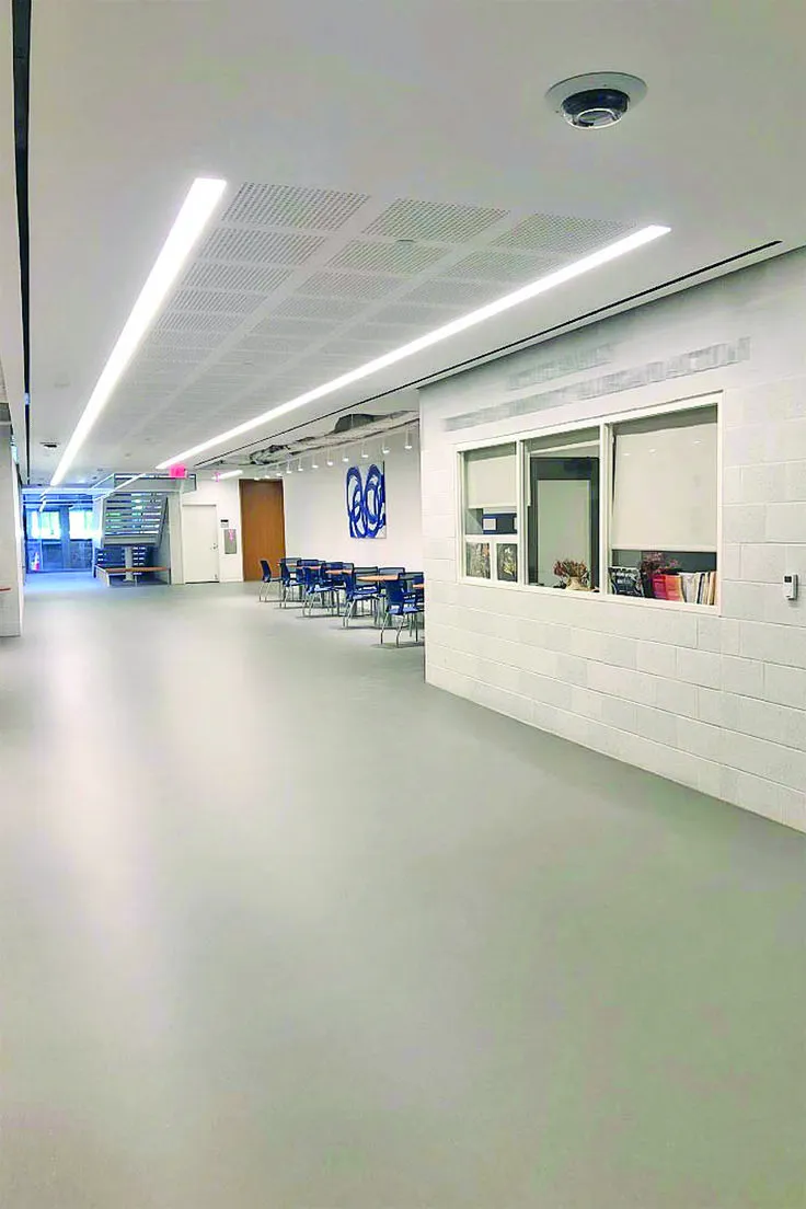 This may contain: an empty room with tables and chairs in the center is lit by recessed lights