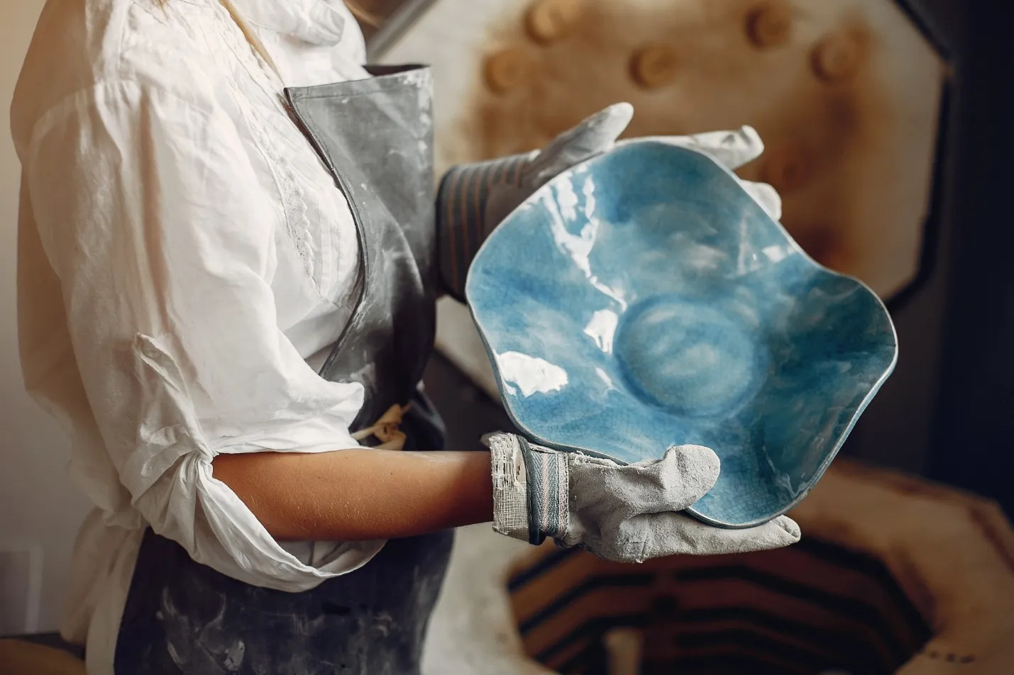 young woman makes pottery in workshop
