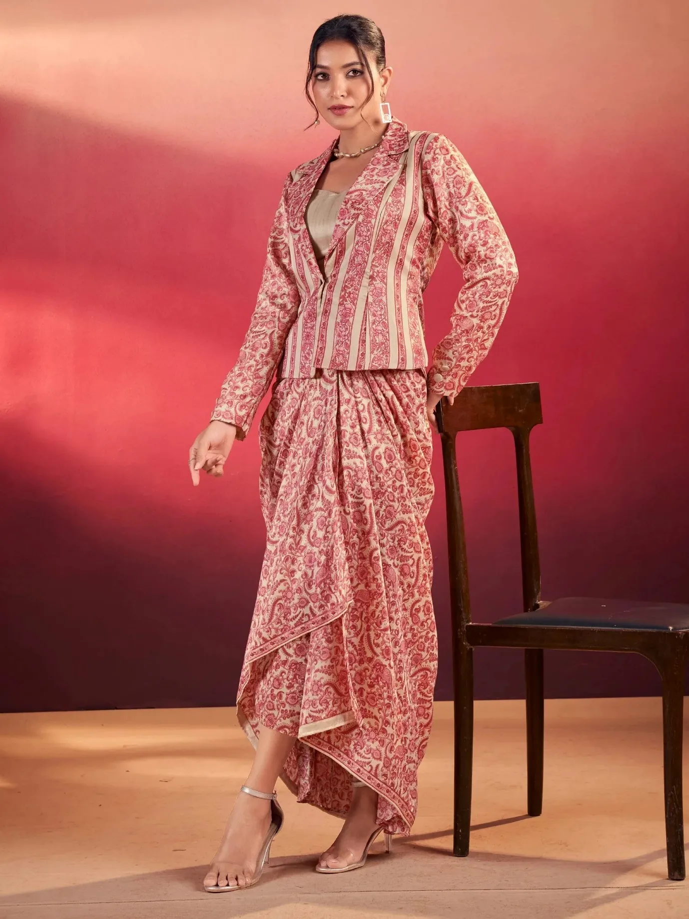Woman wearing a red and cream floral print ethnic co-ord set with a tailored jacket and skirt